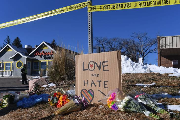 Bouquets of flowers and a sign reading "Love Over Hate" are left near Club Q, an LGBTQ nightclub in Colorado Springs.